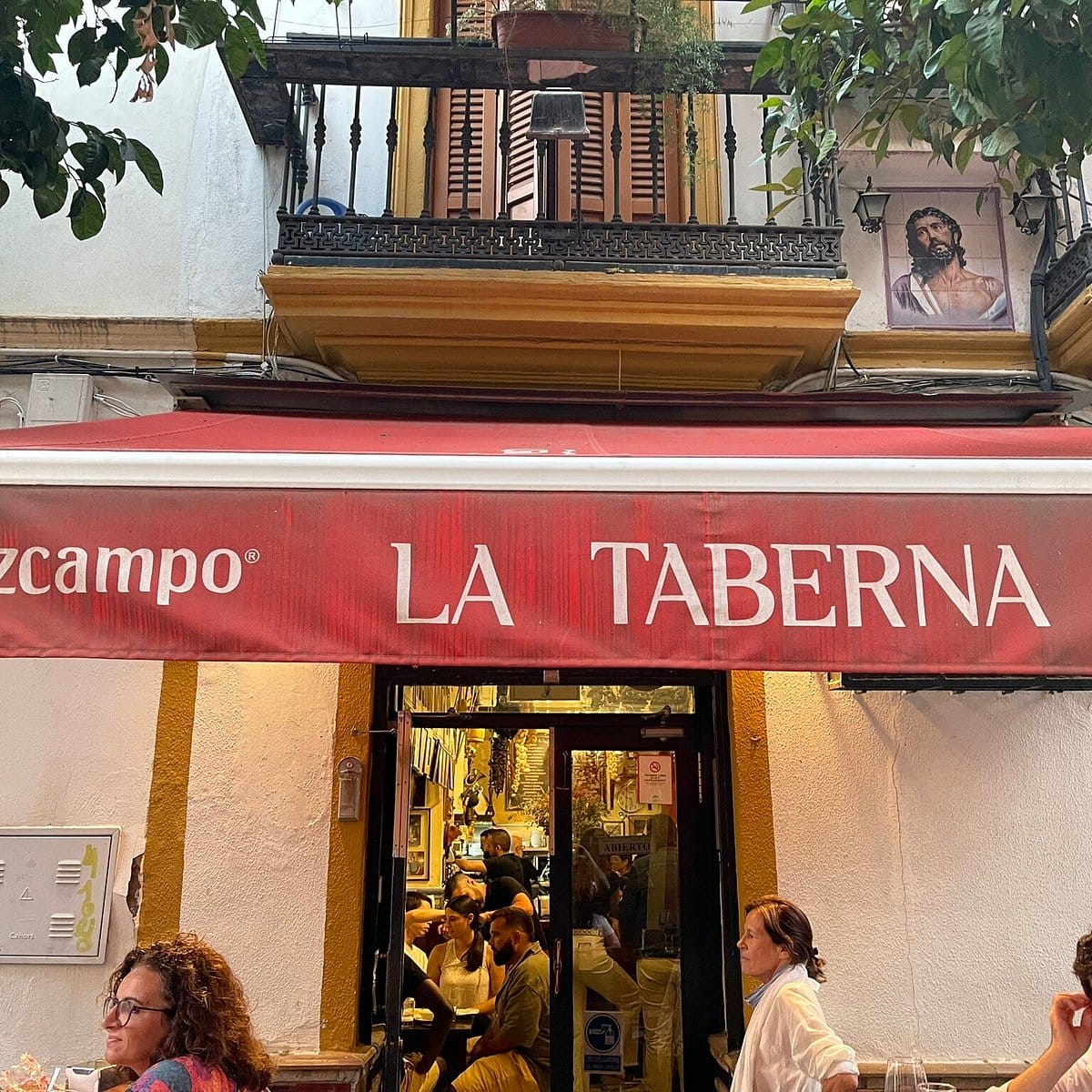red awning over a glass doorway into a bar and restaurant.