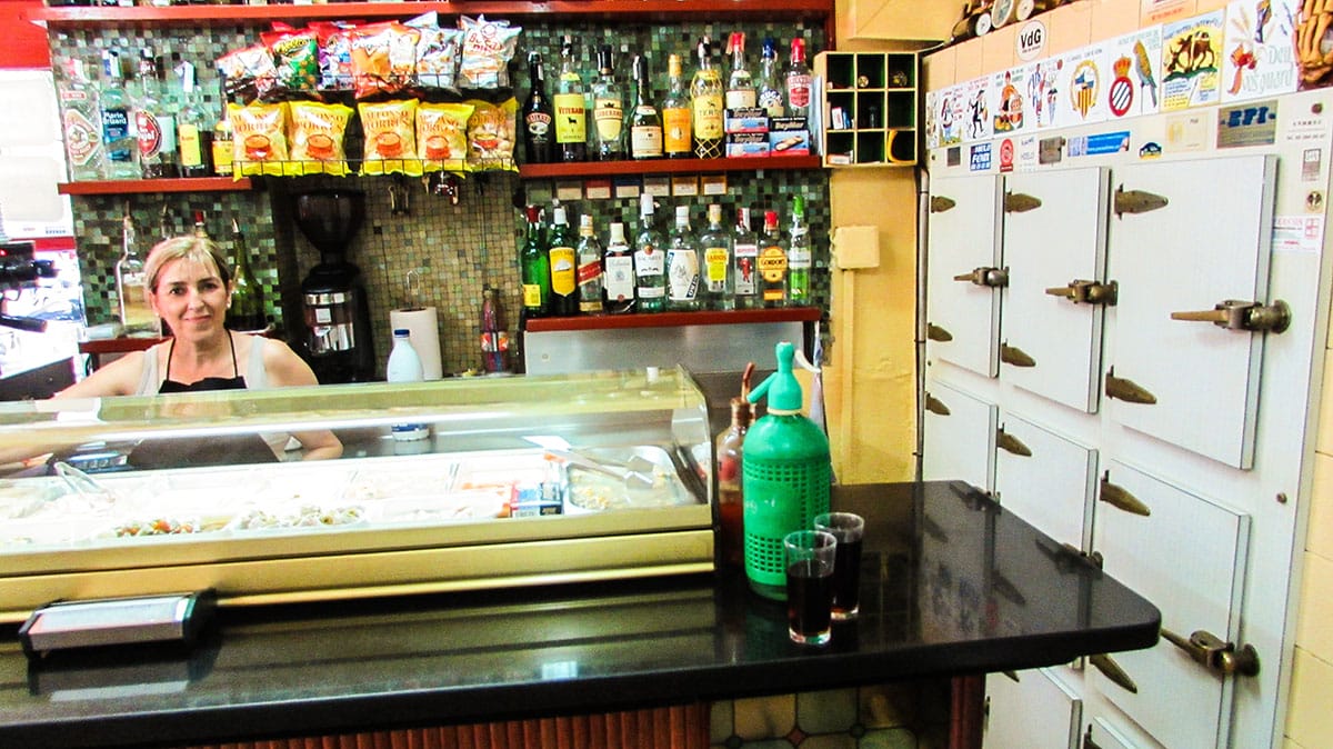 lady smiling behind a counter at La Vermuteria del Tano in Barcelona.