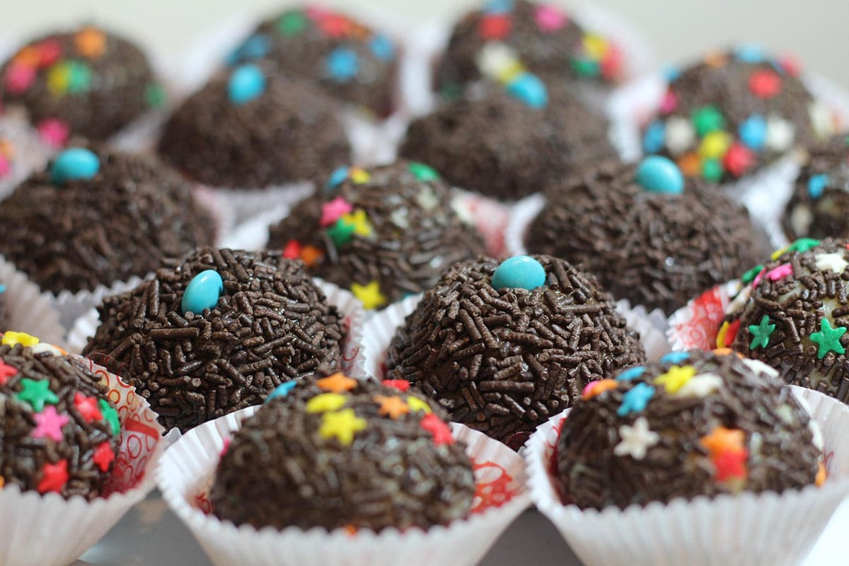 small chocolate desserts covered with sprinkles in paper cups.