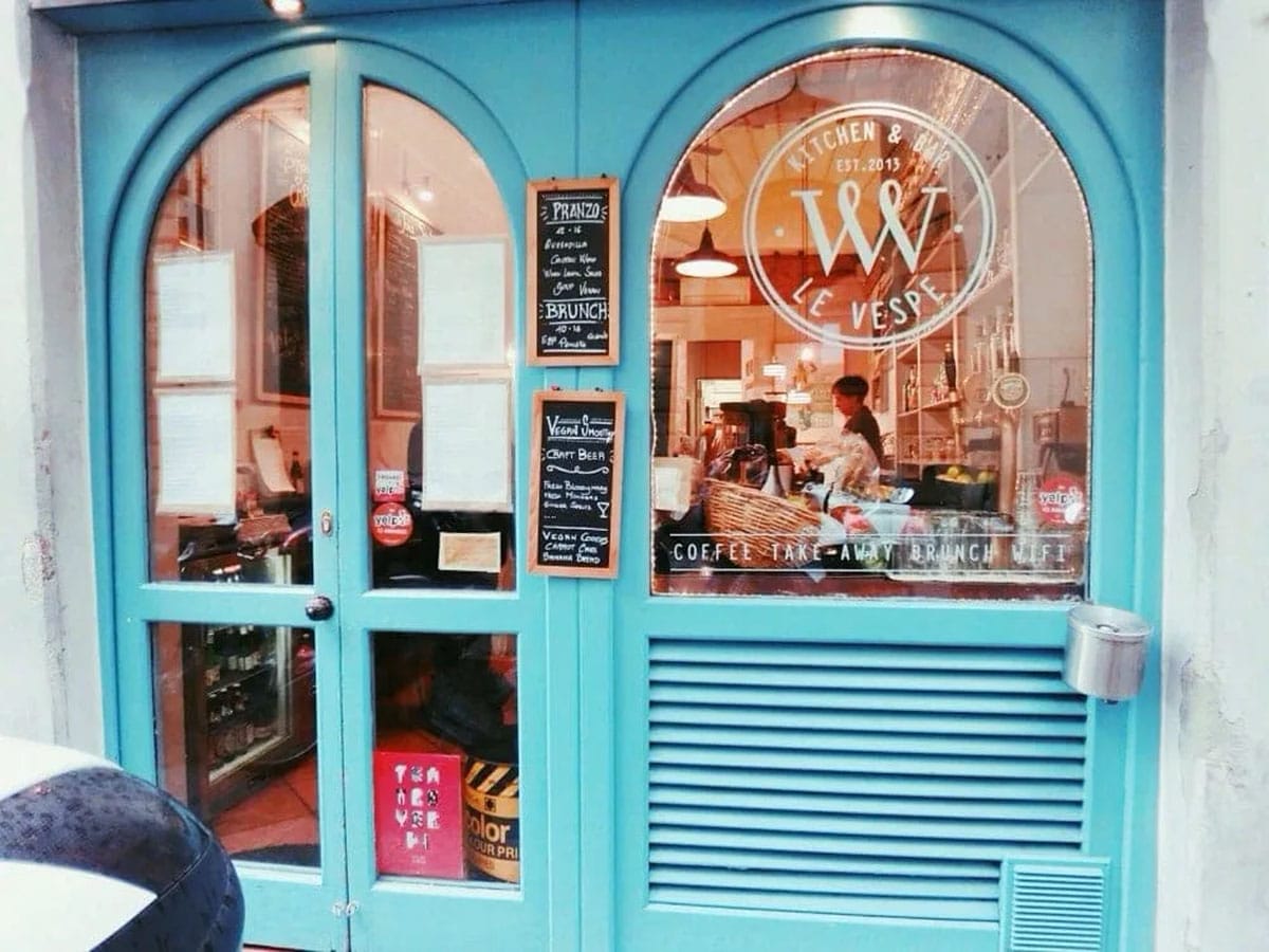 blue door and window looking into a small restaurant.