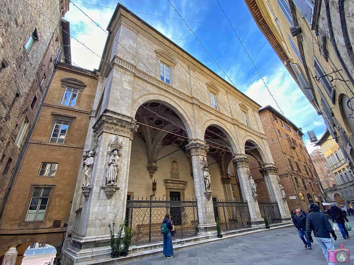 historical stone building adorned with sculptures on a narrow stone street.