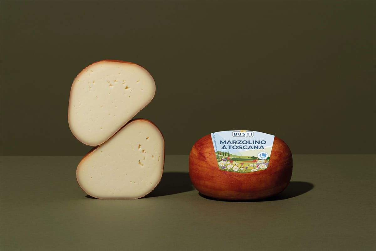 two pieces of red-coated cheese, one sliced in half.