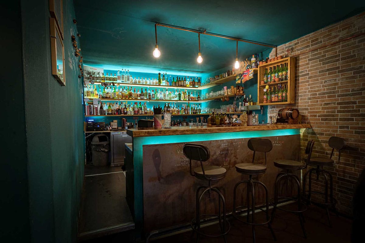 cozy bar with a blue wall and brick wall.