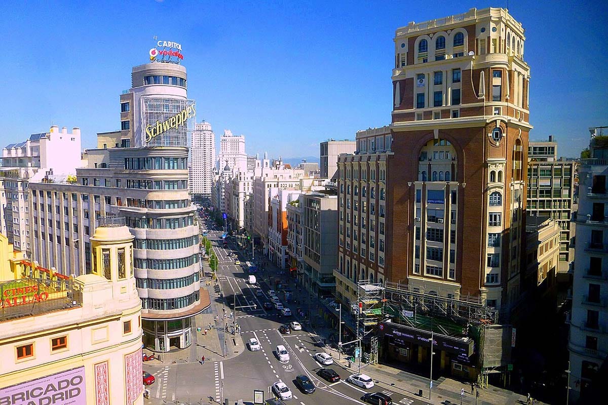 aerial view of y-shaped street with tall buildings on each side and cars driving below.