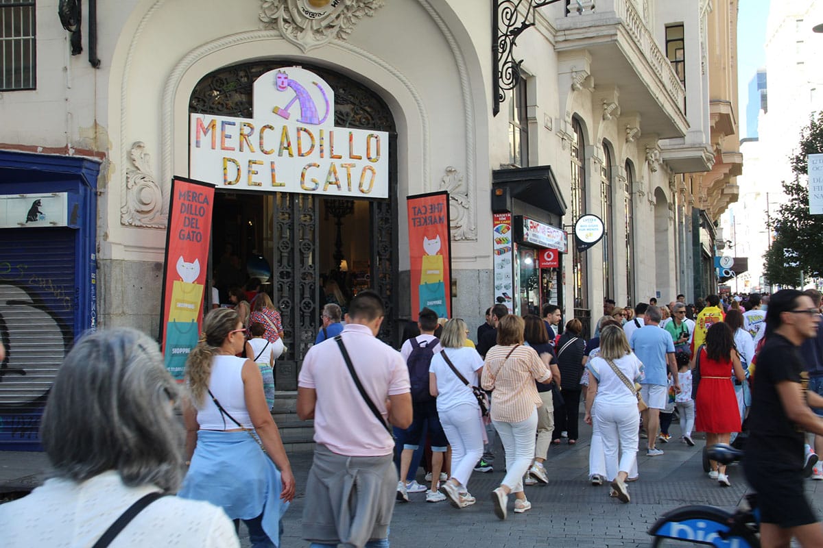 people walking outside of the entrance to Mercadillo del Gato.
