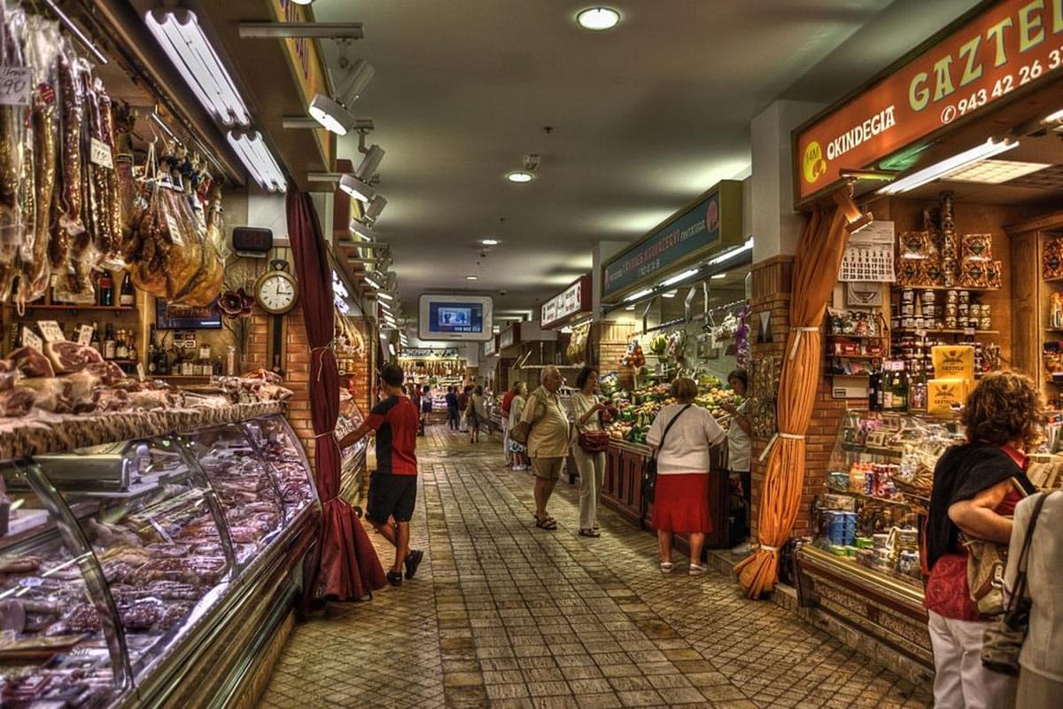 people browsing an indoor food market.