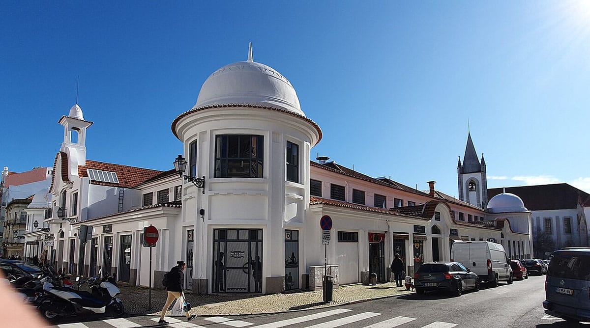 large white building with a clay tiled roof on the corner of two streets.