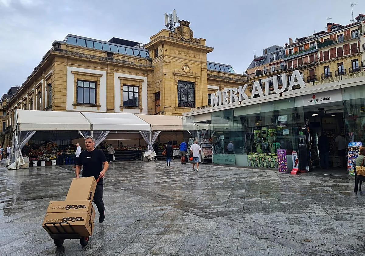 shoppers entering a market with a glass doorway and long low roof.