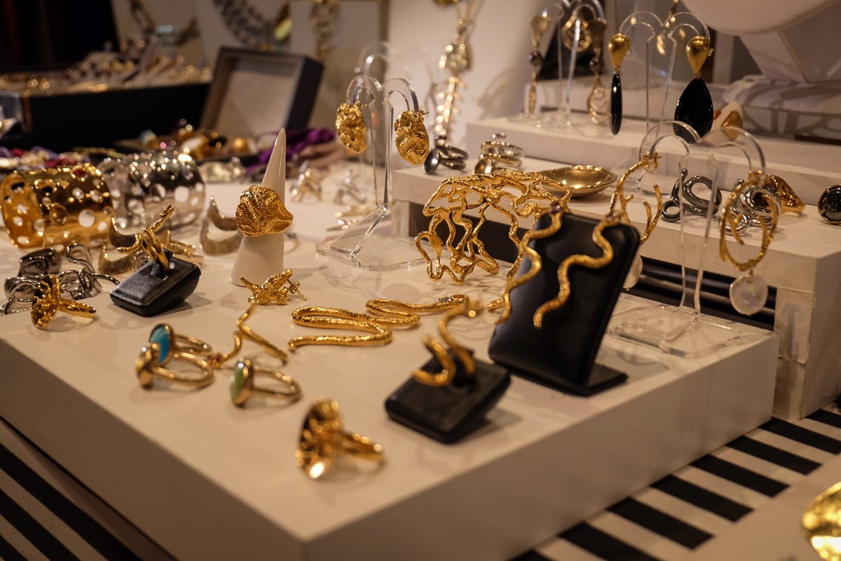 gold jewelry on a white display stand in an indoor market.