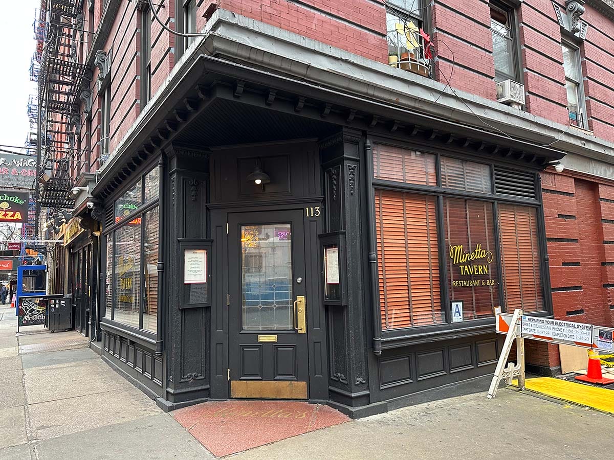 multi-story brick building with a black door on the corner.