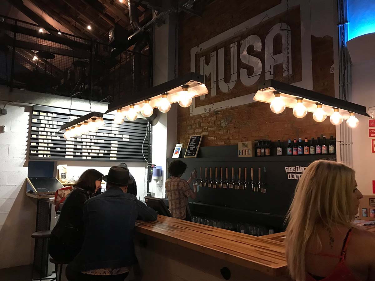 bar and beer taps with a large sign behind the counter.