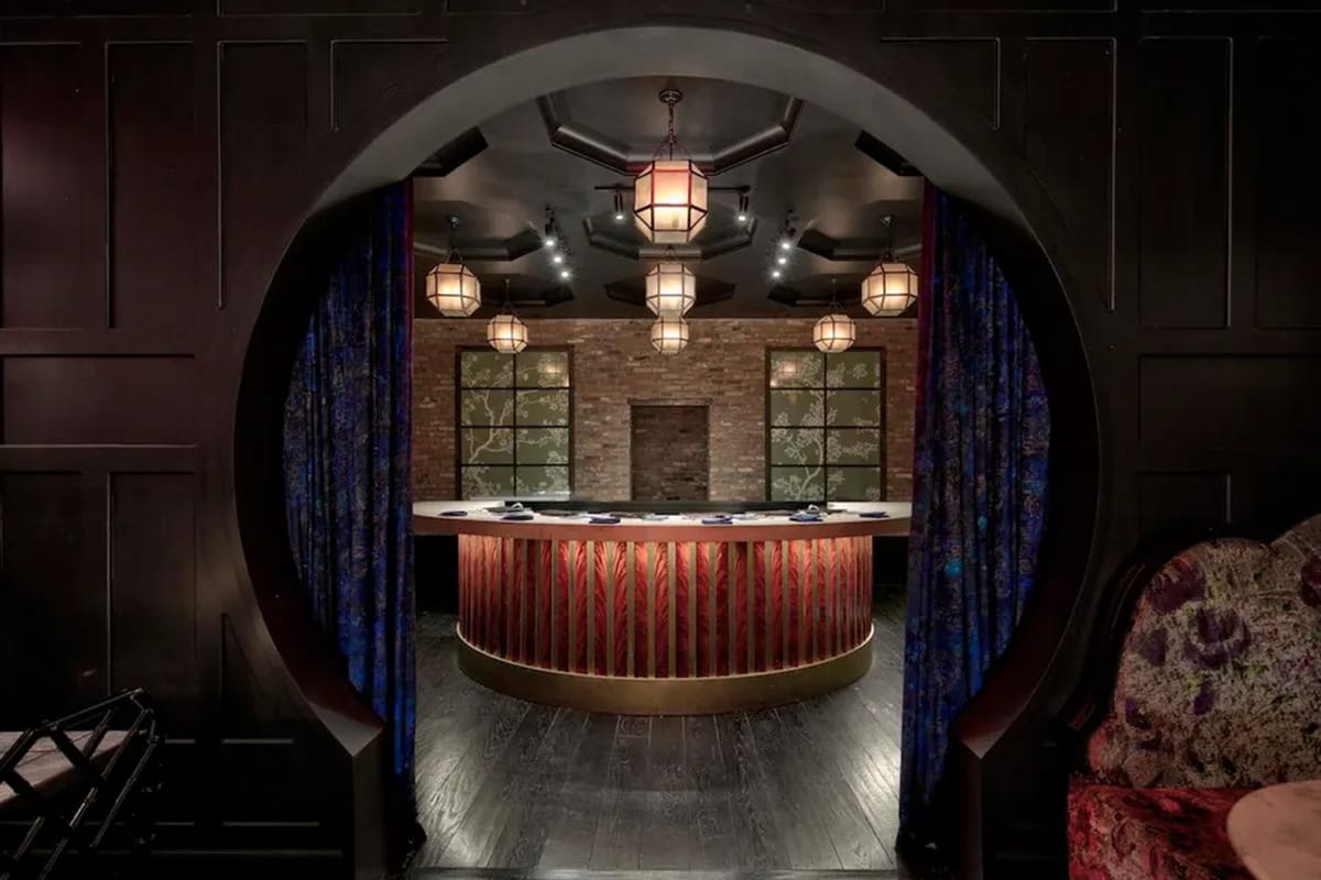 purple velvet-curtained round entrance to a room with a crescent-shaped sushi bar in the center.