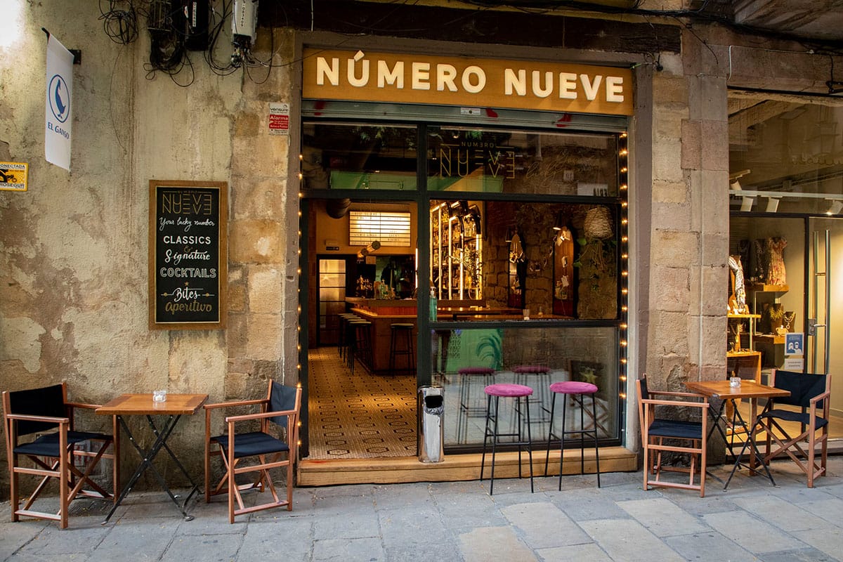 glass door and window leading into a dimly lit cocktail bar.