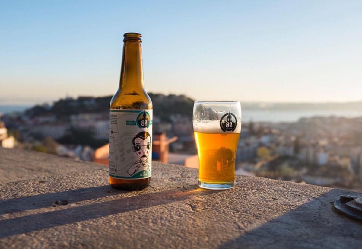 bottle and glass of beer with Lisbon in the background.