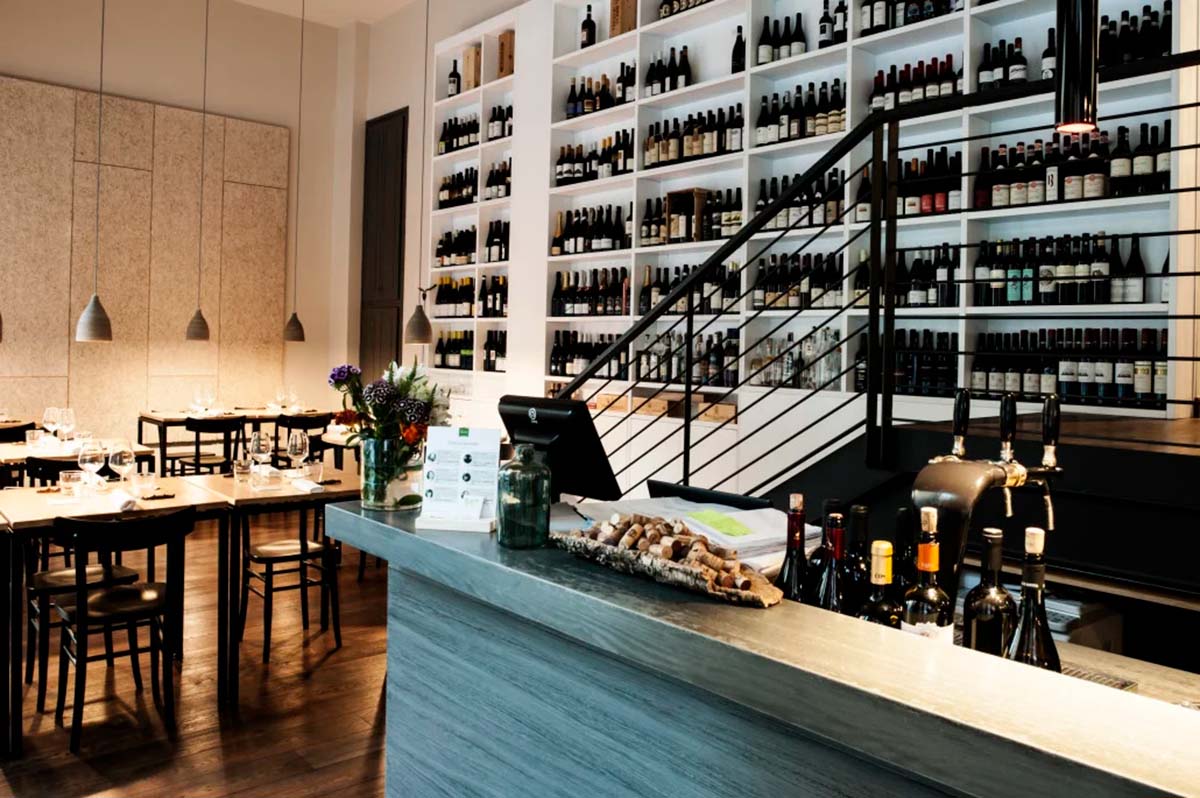 shelves of wine bottles on the wall of a restaurant.