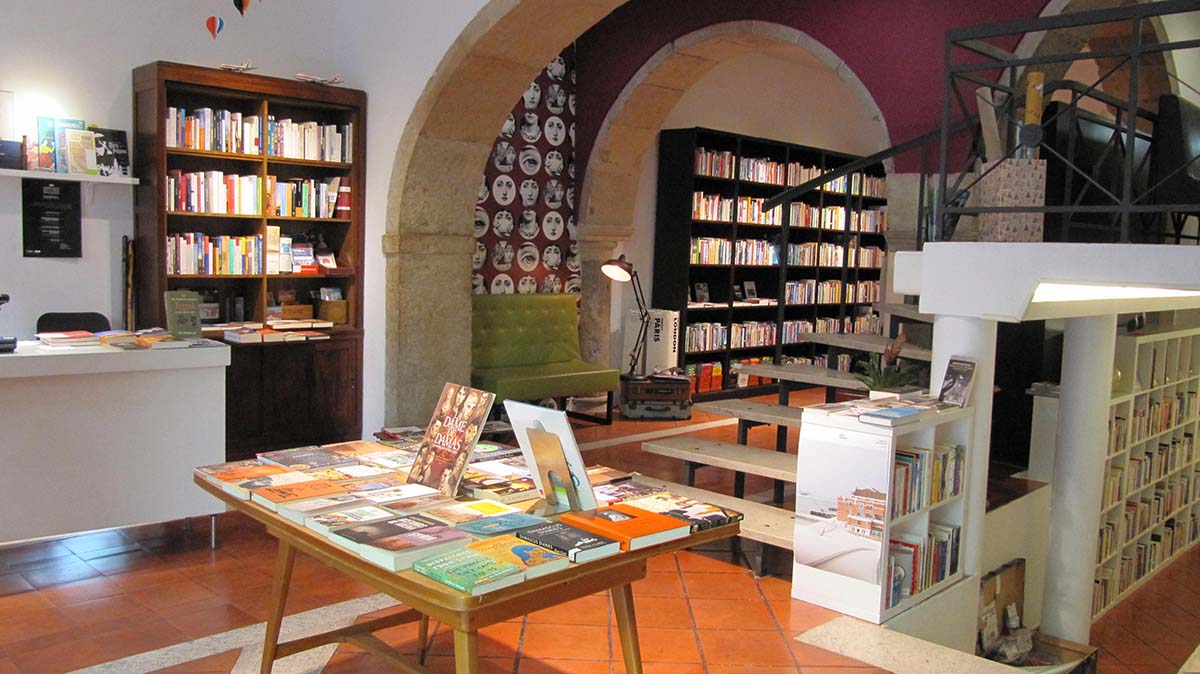 bookstore with shelves of books and tables with arched ceilings.