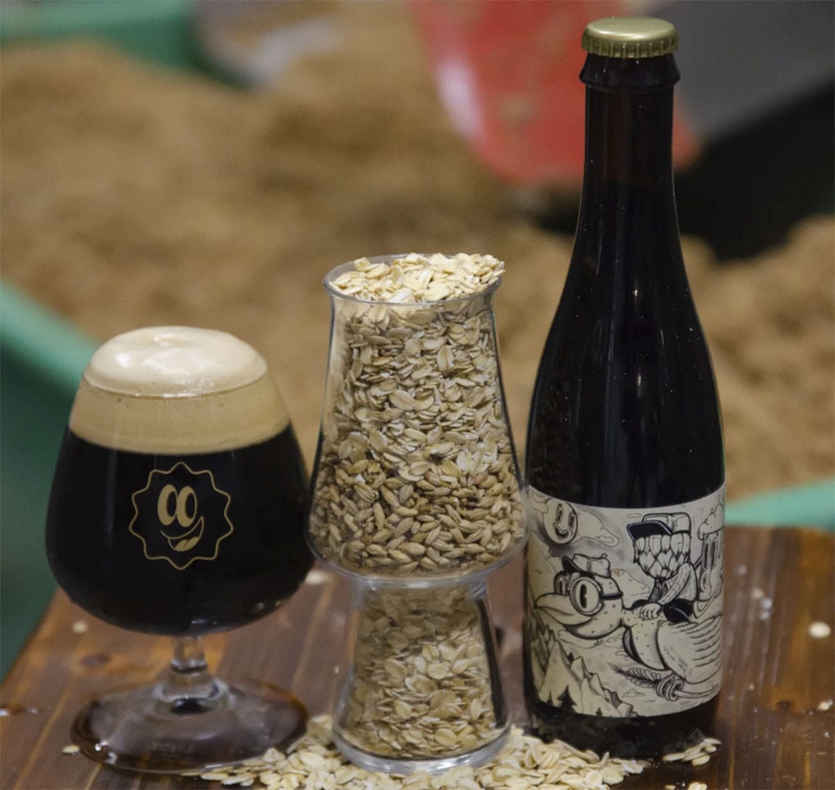 glass of oatmeal stout with oatmeal and a bottle.
