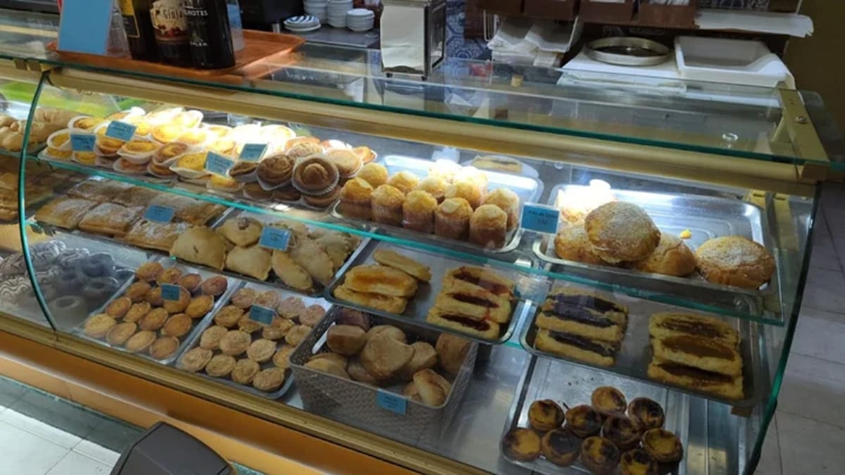 glass case of pastries and custard tarts in a bakery.