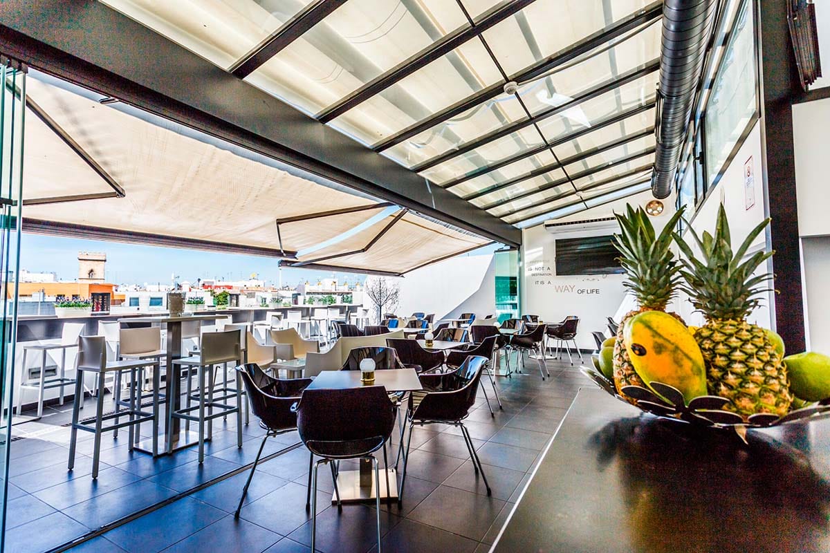 tables and chairs on a partially covered outdoor terrace.