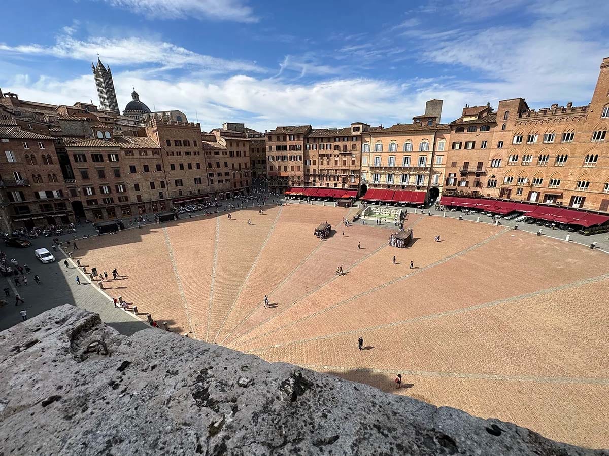 view of a large, shell-shaped piazza surrounded by tall stone buildings.