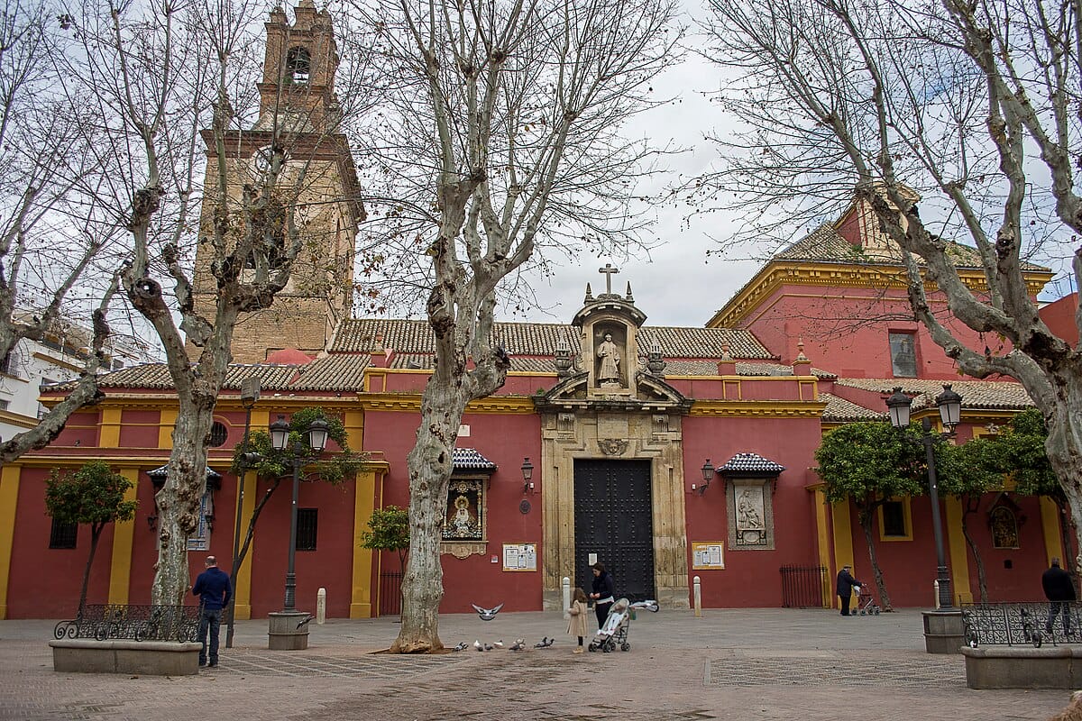a red building with a tall bell tower and a large black door.