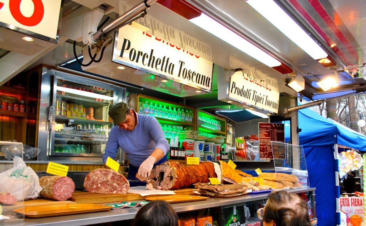 man slicing porchetta in a Roman market.