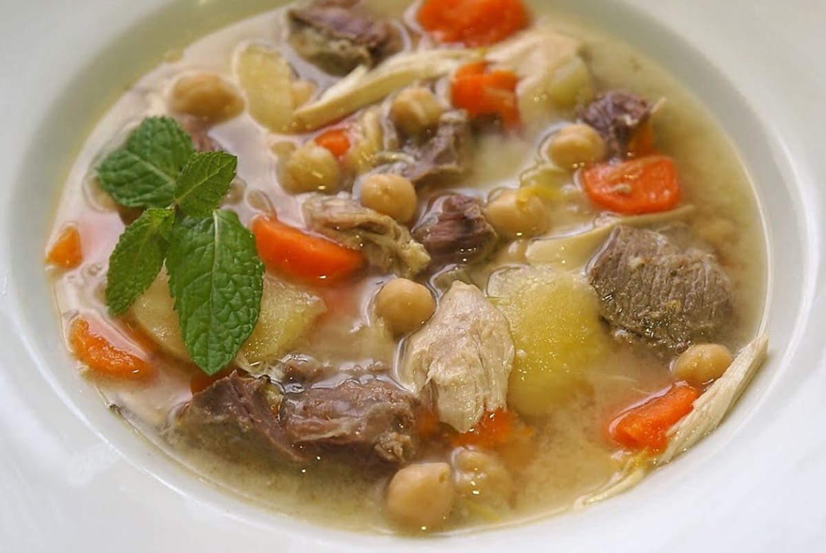 bowl of stew garnished with fresh herbs.