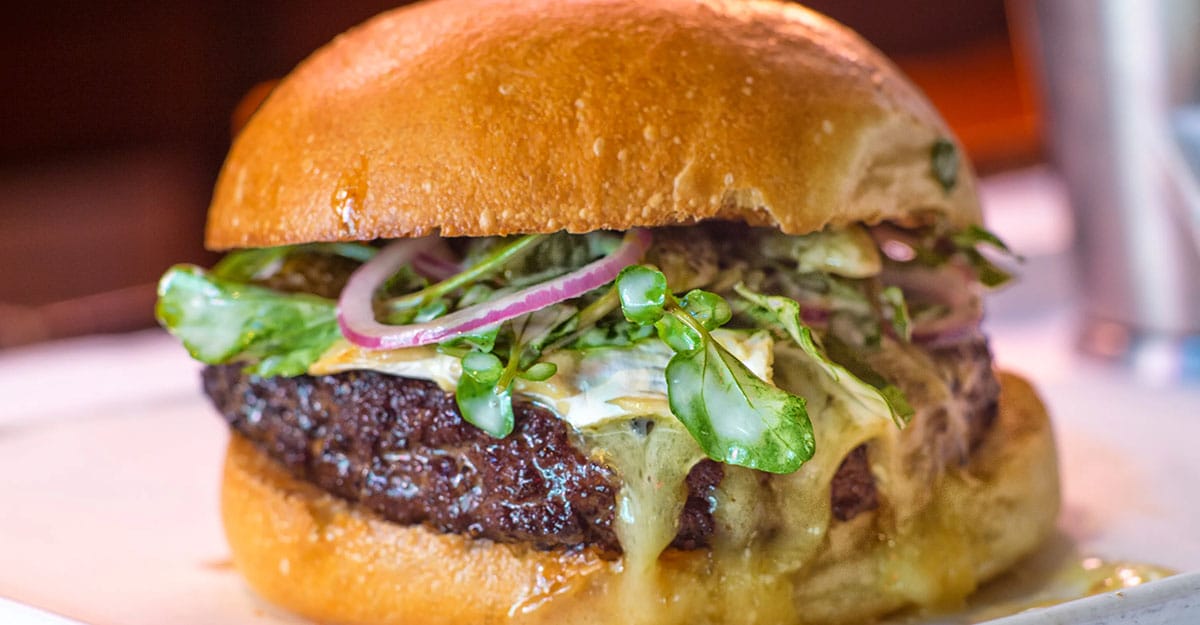 cheeseburger with lettuce and onion on a golden bun.