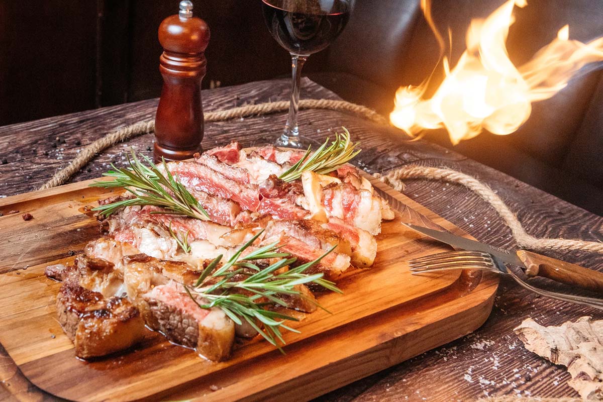 medium-done steak sliced on a wooden cutting board.