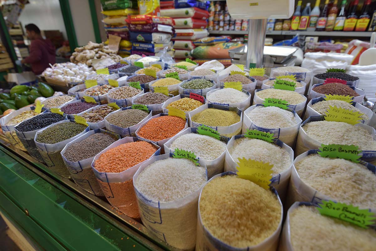 bags of rice, lentils, and risotto for sale at an indoor Roman food market.