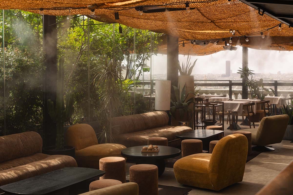 couches and chairs on a rooftop restaurant and bar.