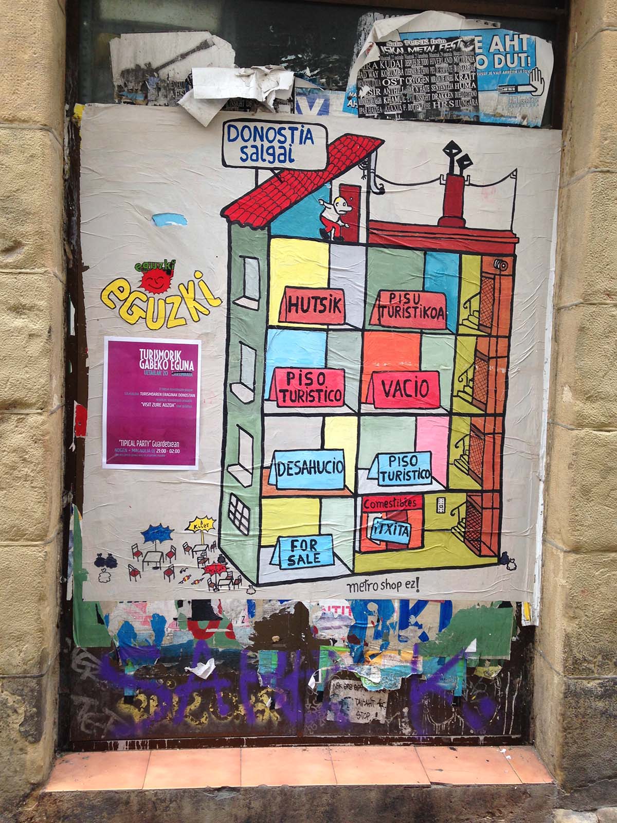 street art on a wall depicting a four-story apartment building with words in Basque on cards in each room.