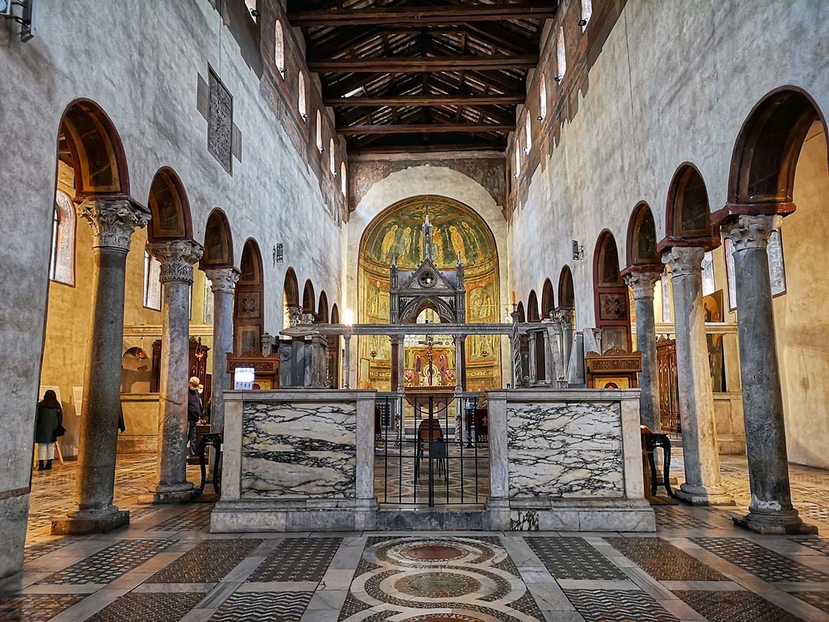 mosaic floored-basilica with arched ceiling and two rows of columns.