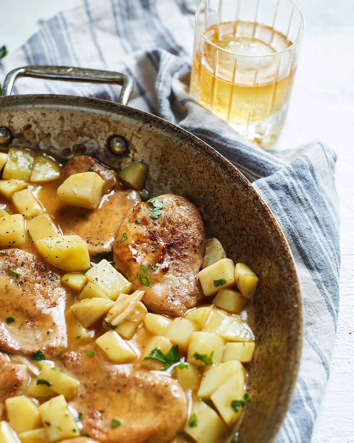 whisky sauce with pork and potatoes in a skillet.