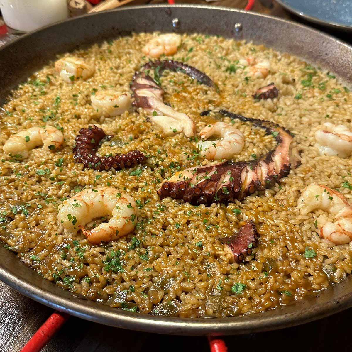 large seafood paella in a shallow pan.