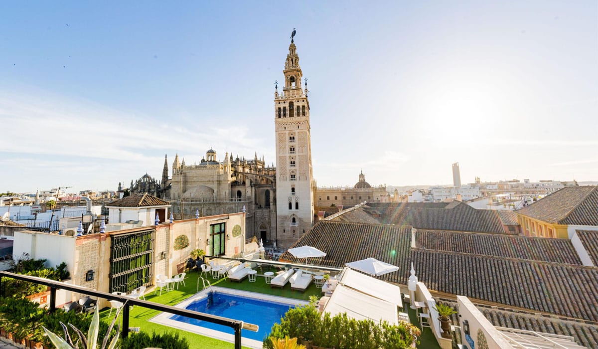 a rooftop terrace with a view of a tower and other historic buildings.