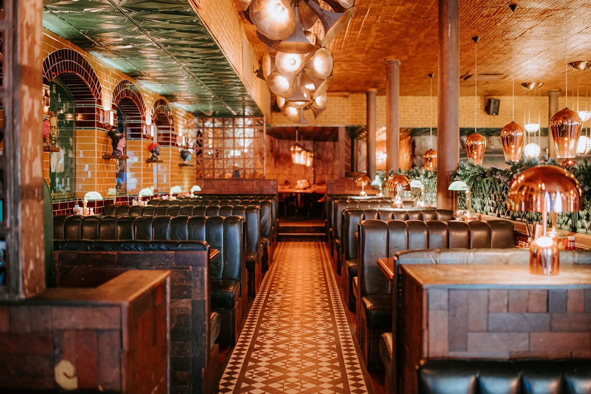 leather-upholstered booths in a restaurant with tiled walls and floors.