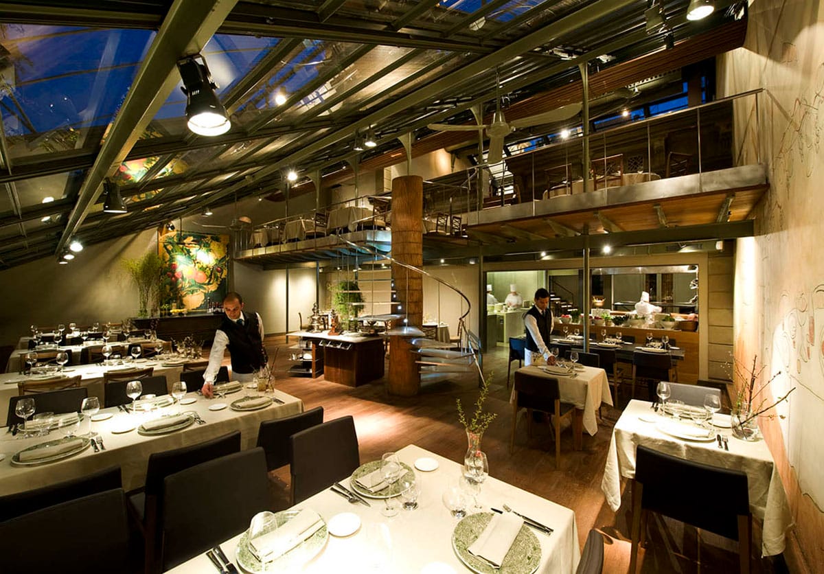 dimly lit, glass-ceilinged restaurant with two levels.