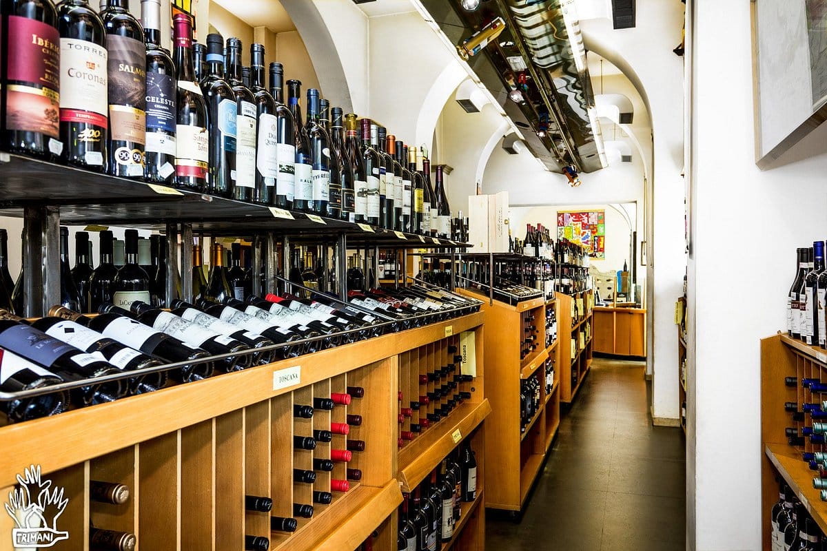 shelves of wine bottles in a high-ceilinged wine store.