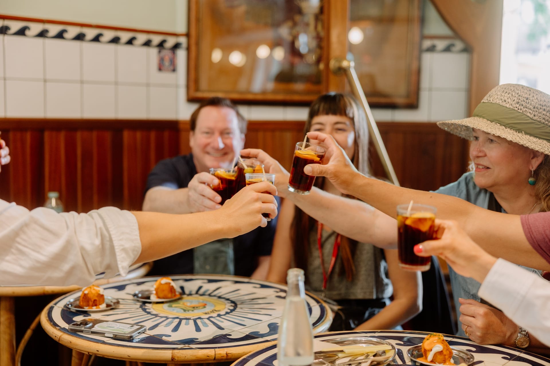 people toasting with small glasses of Spanish vermouth.
