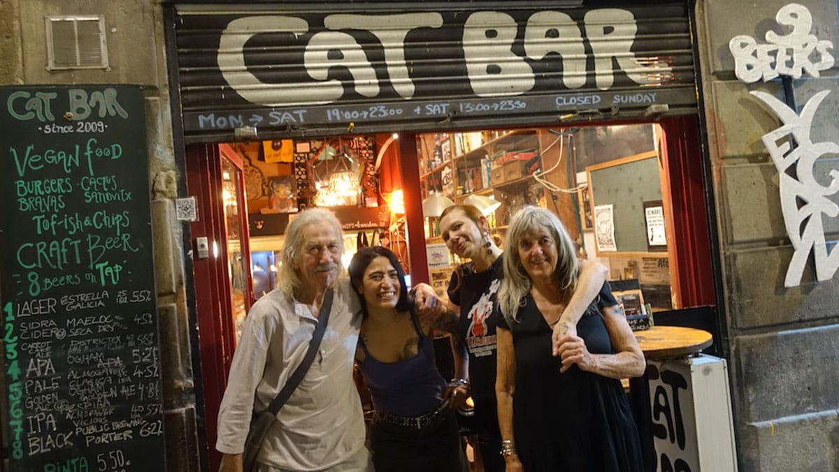 three women and a man smiling outside the entrance to CatBar.