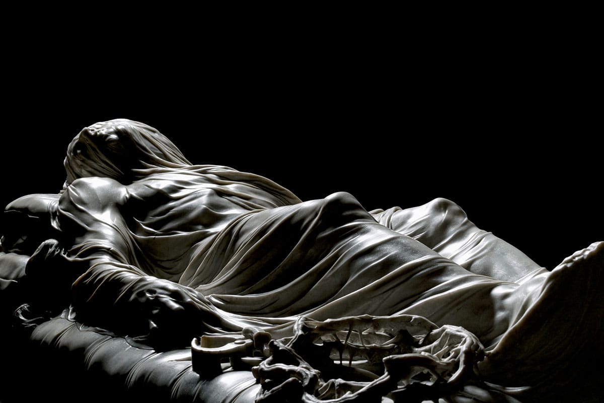 marble statue of a veiled man in dramatic lighting.