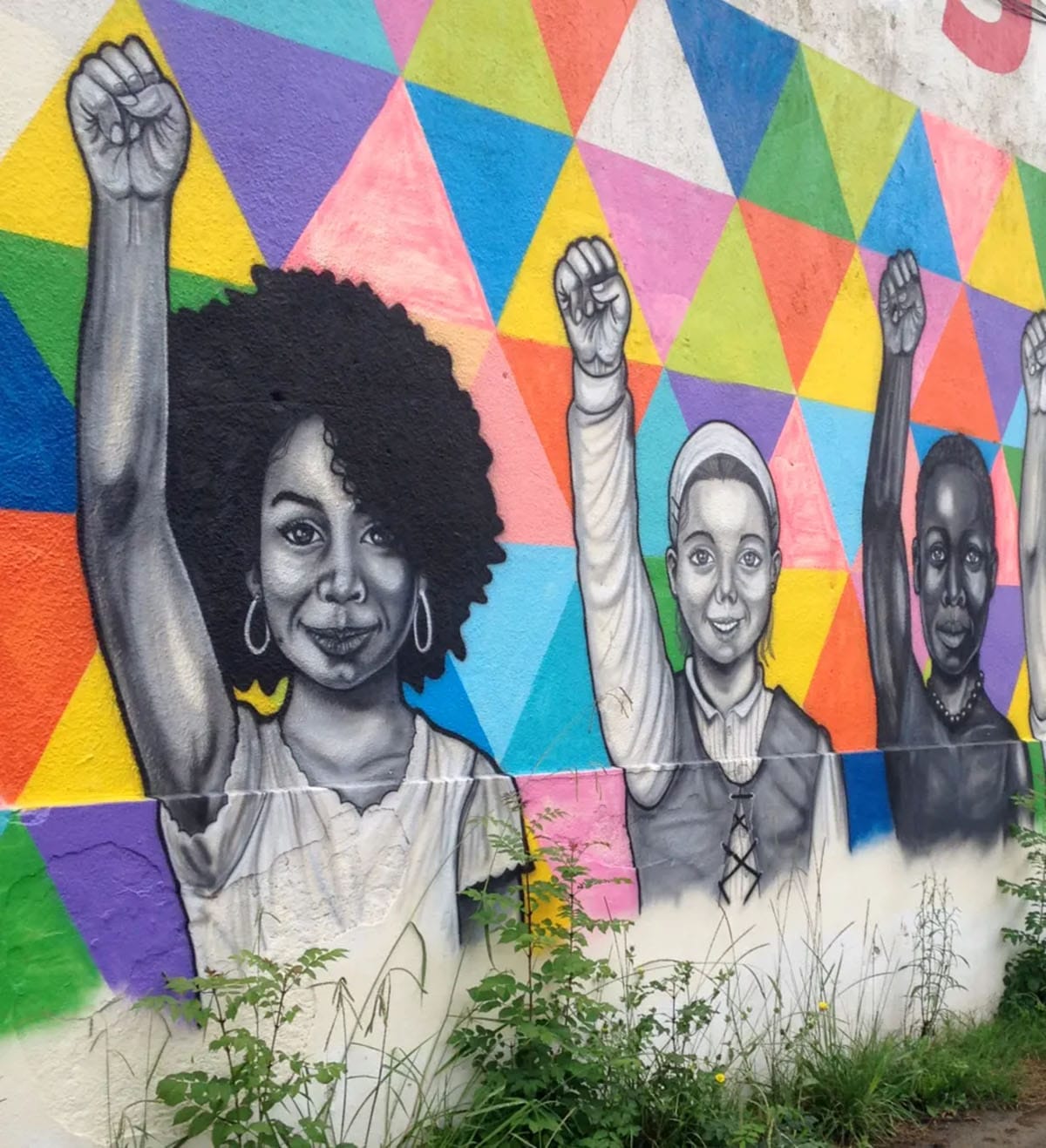 street art depicting women from around the world each raising a hand in a fist above their head.