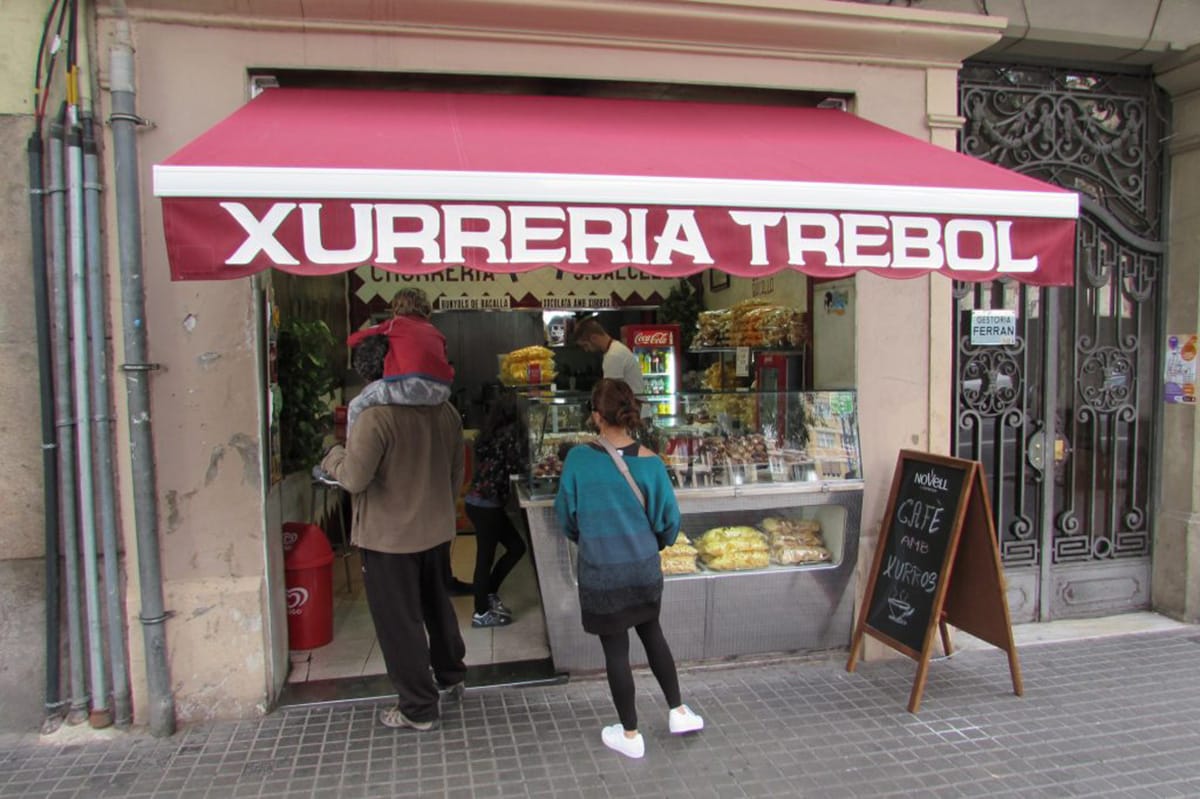 family walking into the entrance of a hot chocolate and churro shop.