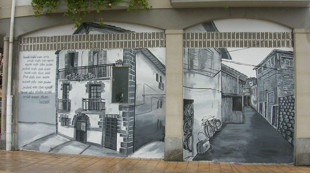 detailed black-and-white mural of brick houses and a street.