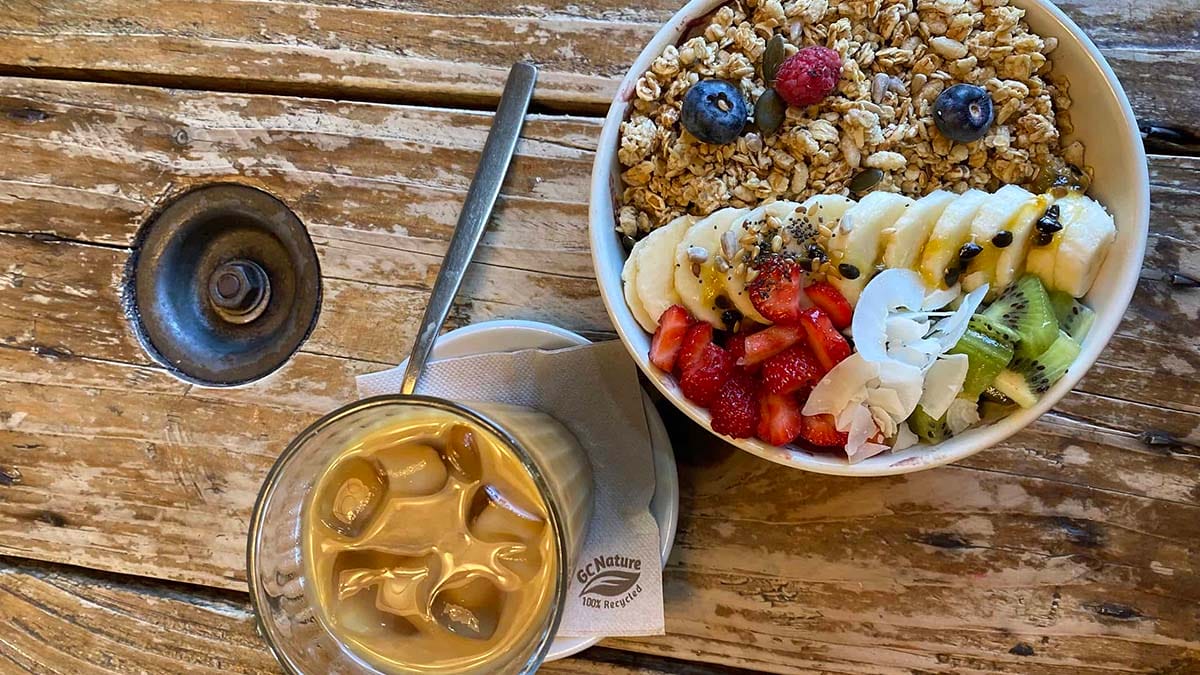 acai bowl with an iced coffee on a wooden table.