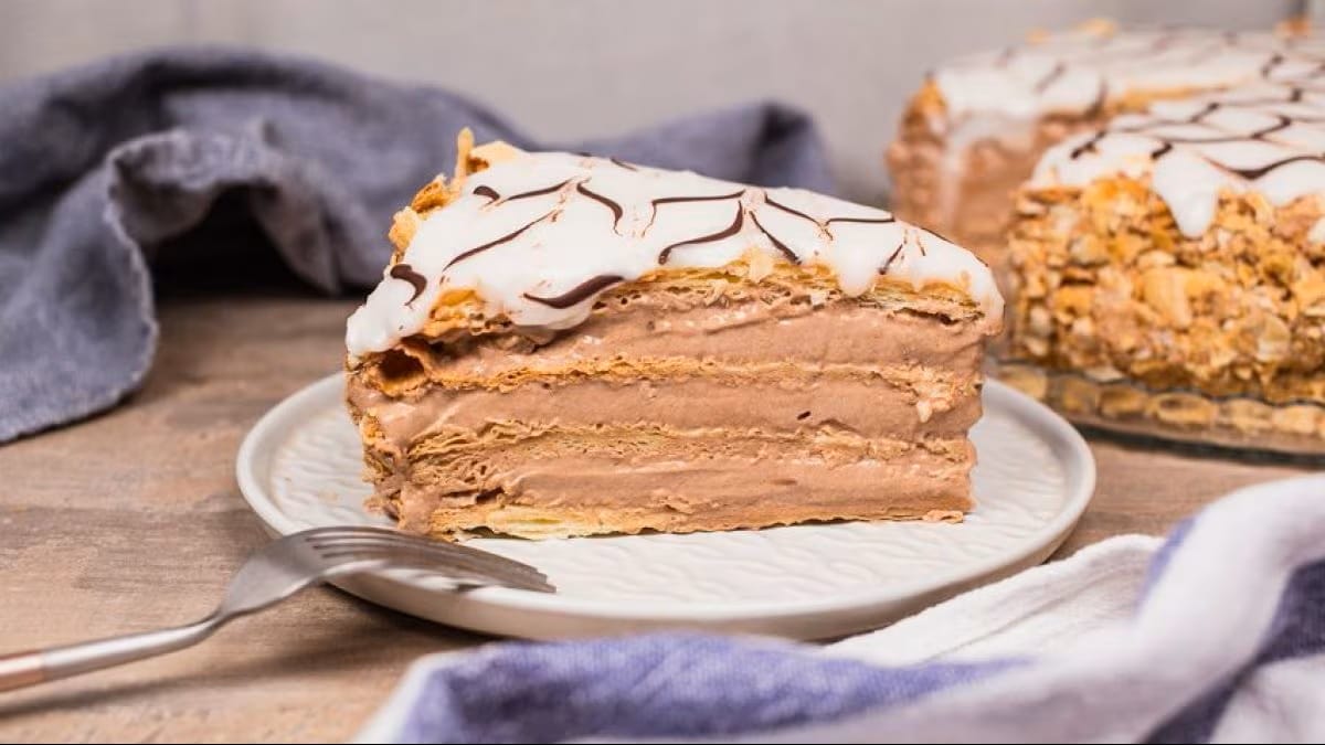 slice of chocolate millefoglie on a white plate with a fork.