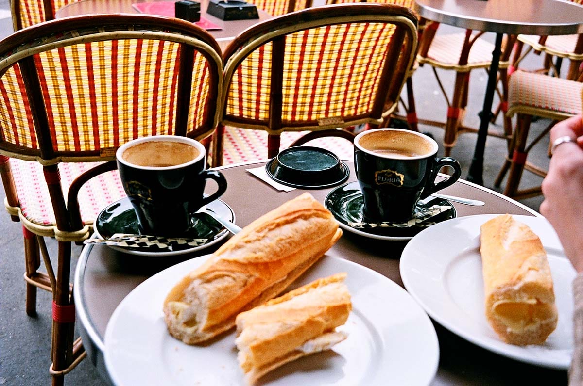 baguettes on plates with coffee at a cafe.