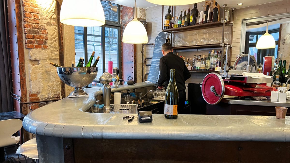 bartender working behind a marble bar at a wine bar.