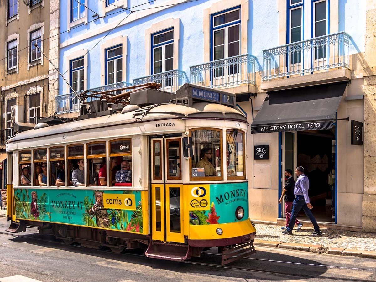 yellow tram 12 stopped in front of a hotel in Lisbon.